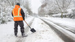 © DELstudio - Worker Clearing Snow from Road with Shovel in Winter. Urban Maintenance and Safety