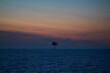 © Igor Hotinsky - Sea landscape with unmanned offshore oil platform in the sea and colourful sunset sky.