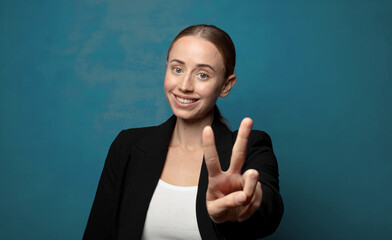 Wall Mural - smiling and looking happy, carefree and positive, gesturing victory or peace with one hand