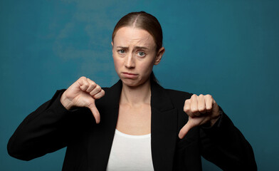 Wall Mural - looking sad, disappointed or angry, showing thumbs down in disagreement, feeling frustrated