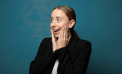 Wall Mural - feeling happy, excited and surprised, looking to the side with both hands on face