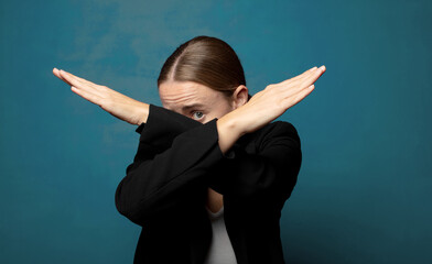 Wall Mural - covering face with hand and putting other hand up front to stop camera, refusing photos or pictures