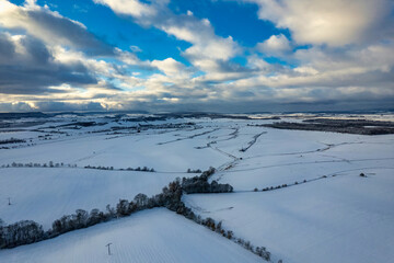 Aerial view of a small German mountain village covered by heavy snow at sunset. Germany.