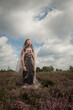© Milou Dirks - art portrait of young asian woman in a field of purple heather wearing a vintage dress and thin fabric