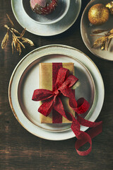 Wall Mural - Christmas present with red ribbon on a plate. Top view