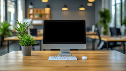 Poster - A sleek computer sits on a wooden desk surrounded by lush plants in a contemporary office space filled with natural light