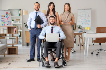 Poster - Team of designers and their male colleague in wheelchair with laptop at office