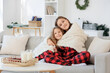 © Pixel-Shot - Cute sisters with warm plaid sitting at home on winter day