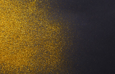 Poster - Golden glitter sand texture on black, abstract background. Yellow dusty shimmer decoration, shiny and sparkling frame, top view,copy space. Holidays and glamour concept.