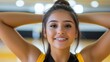 © Matt - Cheerful young woman on a basketball court with arms raised wearing a yellow and black uniform