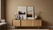 © azi - Minimalist living room interior with light wood sideboard, framed landscape prints, and decorative objects.