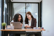 © Witoon - Two businesswomen in an office, business colleagues are having a conversation.