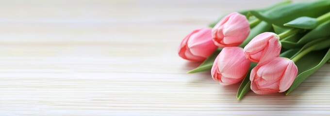 Poster - A bouquet of pink tulips arranged on a light wooden surface.