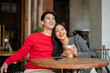© bongkarn - A young, charming Asian couple are enjoying a coffee date, sharing happy moments together.