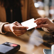 © Katewaree - Close-up of two hands exchanging a blank card, presenting a moment of connection in a casual setting with a warm atmosphere and soft lighting suitable for business or personal interactions.