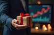 © YULIA - A gift with a red ribbon against the background of a growing investment chart symbolizes New Year's achievements and financial prospects. The concept of business materials and holiday campaigns, New Y