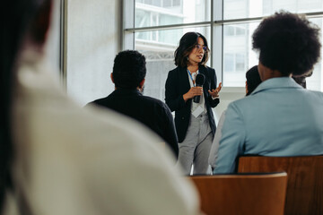 Wall Mural - businesswoman presenting in modern office to coworkers during a meeting