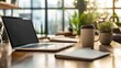 © vadosloginov - Close-up of a modern office desk in a bright workspace featuring a laptop, notebook, coffee cup, and greenery in natural light