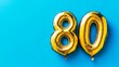 © ryanbagoez - Banner with number 80 golden balloon with copy space. thirty years anniversary celebration concept on a blue background
