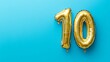 © ryanbagoez - Banner with number 10 golden balloon with copy space. thirty years anniversary celebration concept on a blue background
