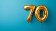 © Pangestu - Banner with number 70 golden balloon with copy space. thirty years anniversary celebration concept on a blue background