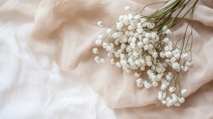 Poster - A delicate arrangement of white flowers on soft fabric, evoking tranquility and beauty.