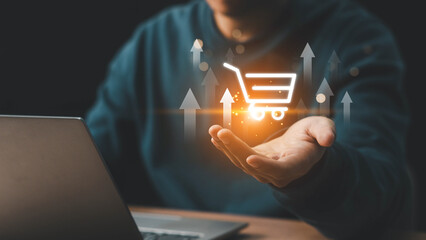 Businessman hand touching to virtual info graphics with trolley cart icons. Increase higher sale volume, shopping trolley cart for online e-commerce business. Online shopping business concept.
