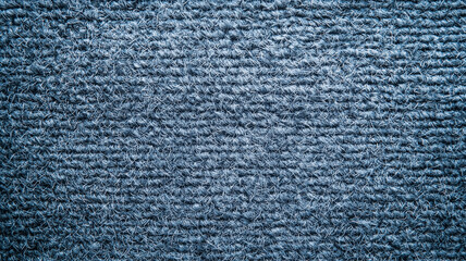 Poster - textured blue wool carpet viewed from above, showcasing intricate woven patterns and soft, cozy appearance. detailed texture highlights craftsmanship and quality of material