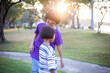 © chaunpis - Cute children play in the park at sunset.