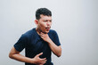 © IgnatiusHarly - an asian young man coughing and holding his neck