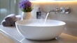 © AFFANYUDA - A modern bathroom sink with steaming hot water flowing into the basin.