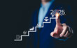 © Supatman - 2025 New Year Business Goals Concept. Businessmen point to '2025' on a staircase, steps toward achieving business goals, growth, and success in the new year. Planning and challenge, investors target,