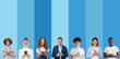 © Damir Khabirov - Group of diverse people holding phones and smiling to camera, isolated on blue background