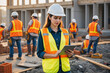 © Derek Brumby - Professional Female Construction Supervisor Using Tablet on Job Site with Crew in Background