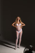 © Tatyana - Beautiful pregnant woman in special white underwear and tights mesh. Advertisement of comfortable pregnancy. Happy blond pregnant girl stand in studio with studio light. Long curly hair. Portrait