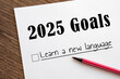 © Evgeniya Primavera - planner of goals and plans for 2025, a sheet of paper with text learn a new language from to do list. planning concept, New Year's resolutions plan.