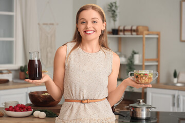 Wall Mural - Young woman with tasty okroshka and kvass in kitchen