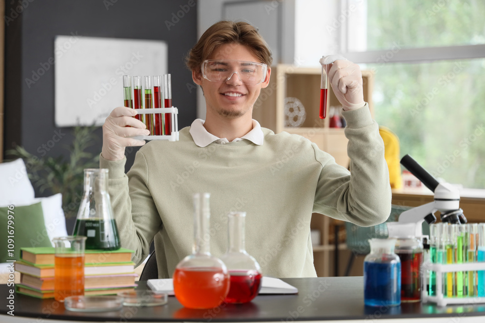 Male student with test tubes studying Chemistry at home