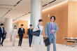 © maroke - オフィスのホールで話しながら歩くビジネスパーソン