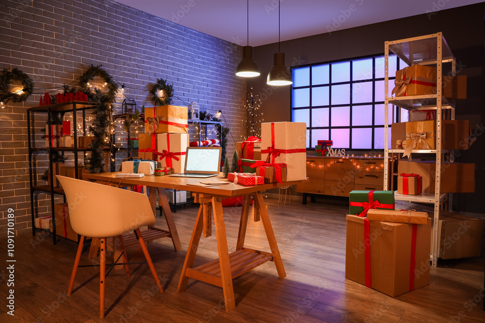 Interior of post office with gift boxes, blank laptop and Christmas decorations at evening