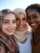© Johannes - Group of three happy multiethnic friends looking at camera. Portrait of young women of different cultures enjoying vacation together. Smiling islamic girl with two african american friends outdoor.