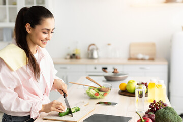 Aufkleber - Portrait Of Young Lady Looking At Digital Tablet Screen Trying New Recipes Cooking Tasty Dinner, Standing In Modern Kitchen At Her Apartment. Weight Loss And Healthy Nutrition Website Concept
