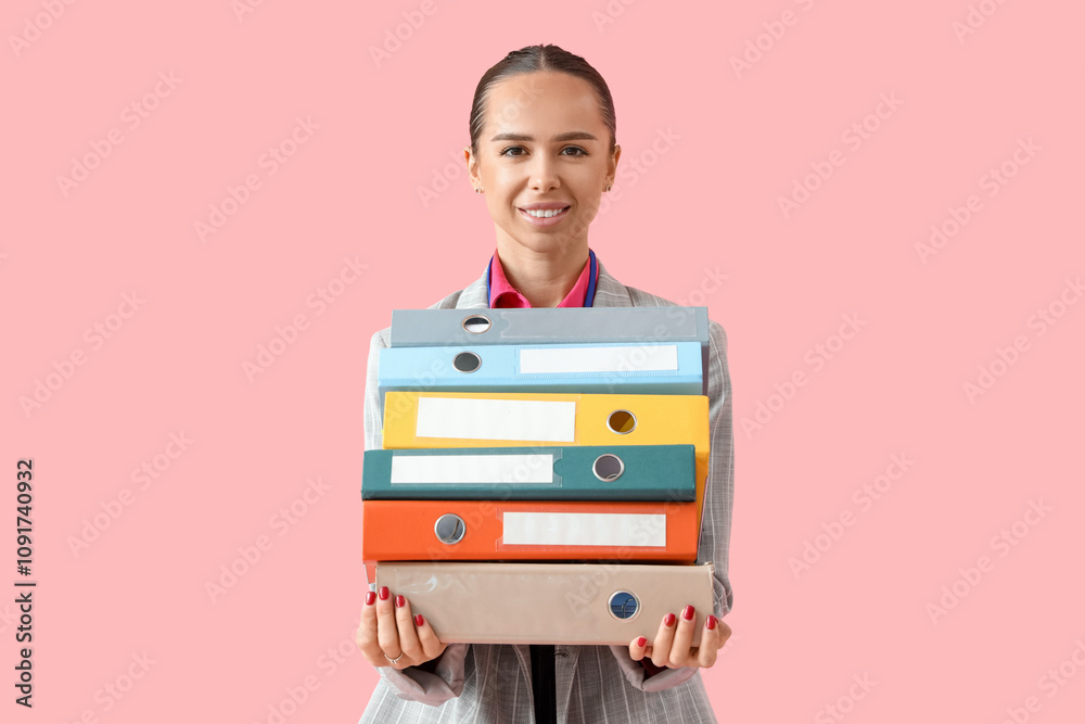 Young businesswoman with folders on pink background