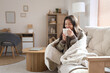 © Pixel-Shot - Young woman with warm plaid and cup of coffee at home on winter day
