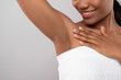 © Prostock-studio - Hair Removal Concept. Unrecognizable Black Female Demonstrating Her Armpit With Smooth Skin, Smiling African American Woman Wrapped In Bath Towel Standing Over Grey Background, Copy Space