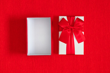 Sticker - Open white gift box with red satin bow on red background. Top view of open empty gift box and lid. Copy space, flat lay background.