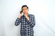 © M Alfan Setyawan - clueless asian man talking on smartphone with confused face expression isolated on white background