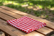 © masud - Red and White Checkered Picnic Tablecloth on Wooden Table in Sunny Park