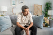 © Pavitra - Asian senior elderly depress man sitting alone in living room at home.