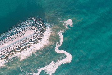 Fototapete - breakwater for the protection of a harbor, aerial top view with a drone